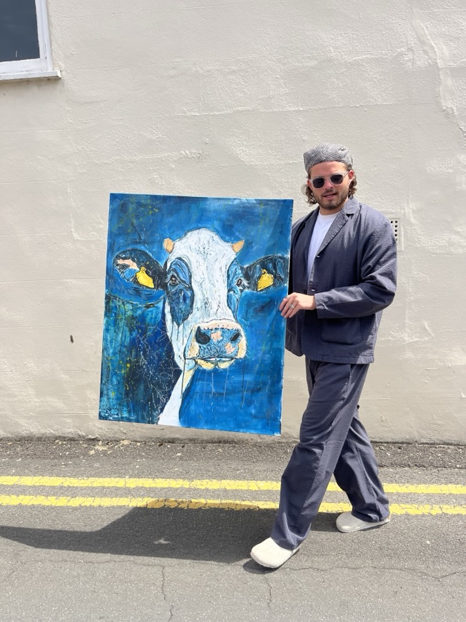 Ben carrying his blue cow painting through the streets