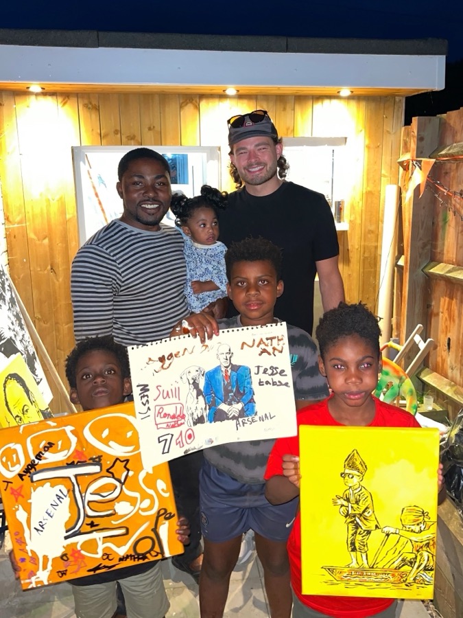 Ben at a workshop with families and their finished paintings