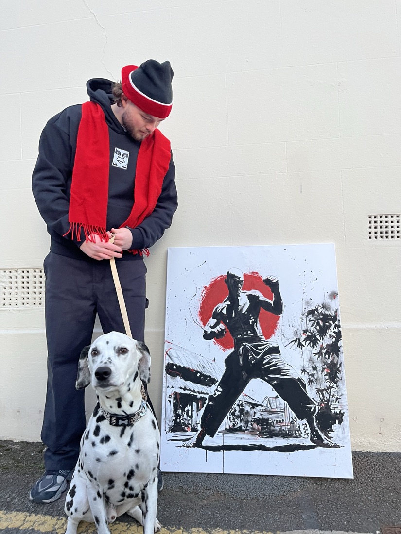 Ben with his dog next to a black-and-red martial artist stencil painting