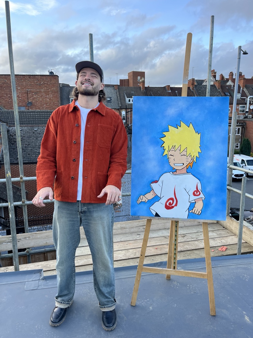 Ben laughing next to his anime-style character painting on an easel