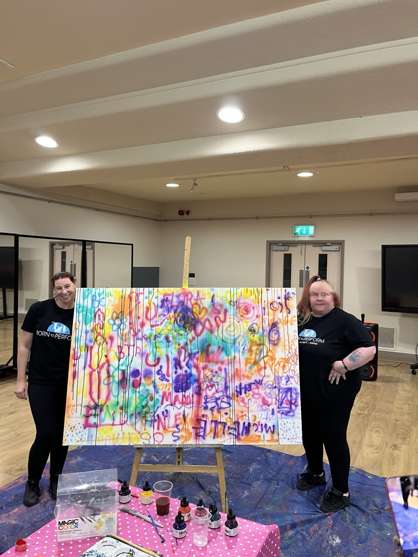 Two Born to Perform artists with their finished splatter-paint canvas