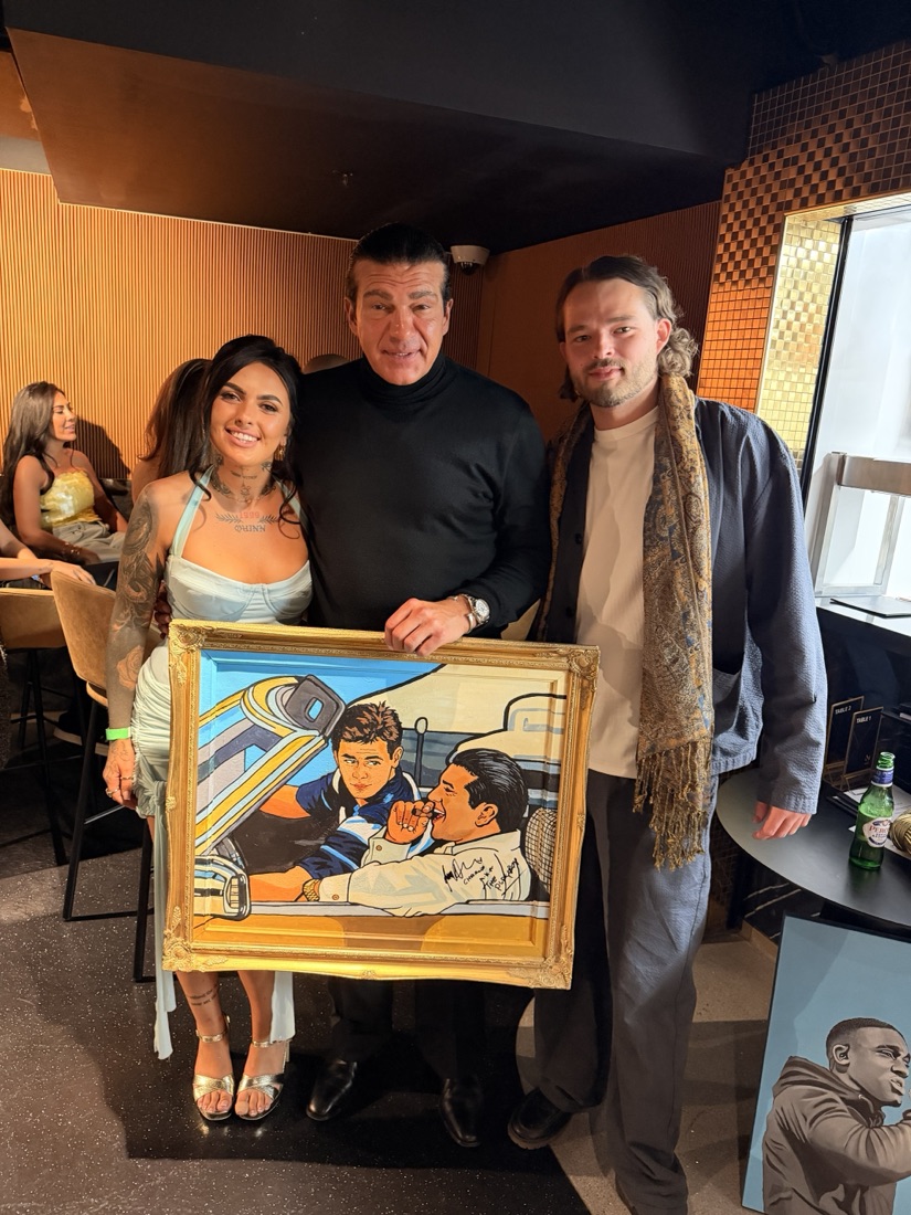 Ben and a client holding a framed commissioned painting together