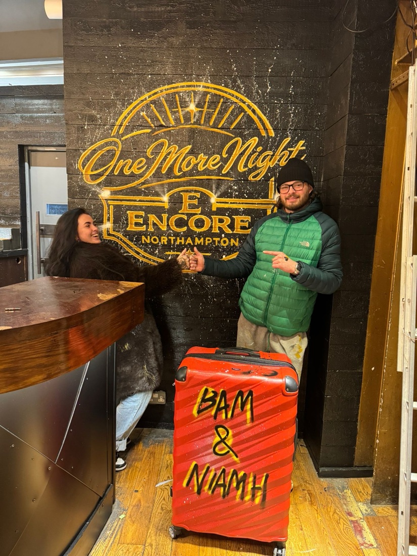 Ben and Niamh fist-bumping in front of the Encore 'One More Night' mural