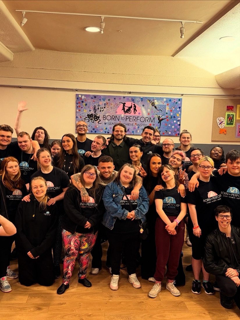 The whole Born to Perform group together in front of their hand-painted studio sign