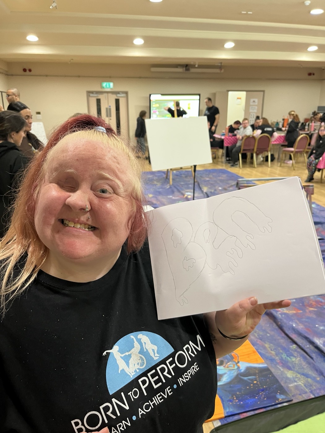 A Born to Perform participant beaming with the board they made