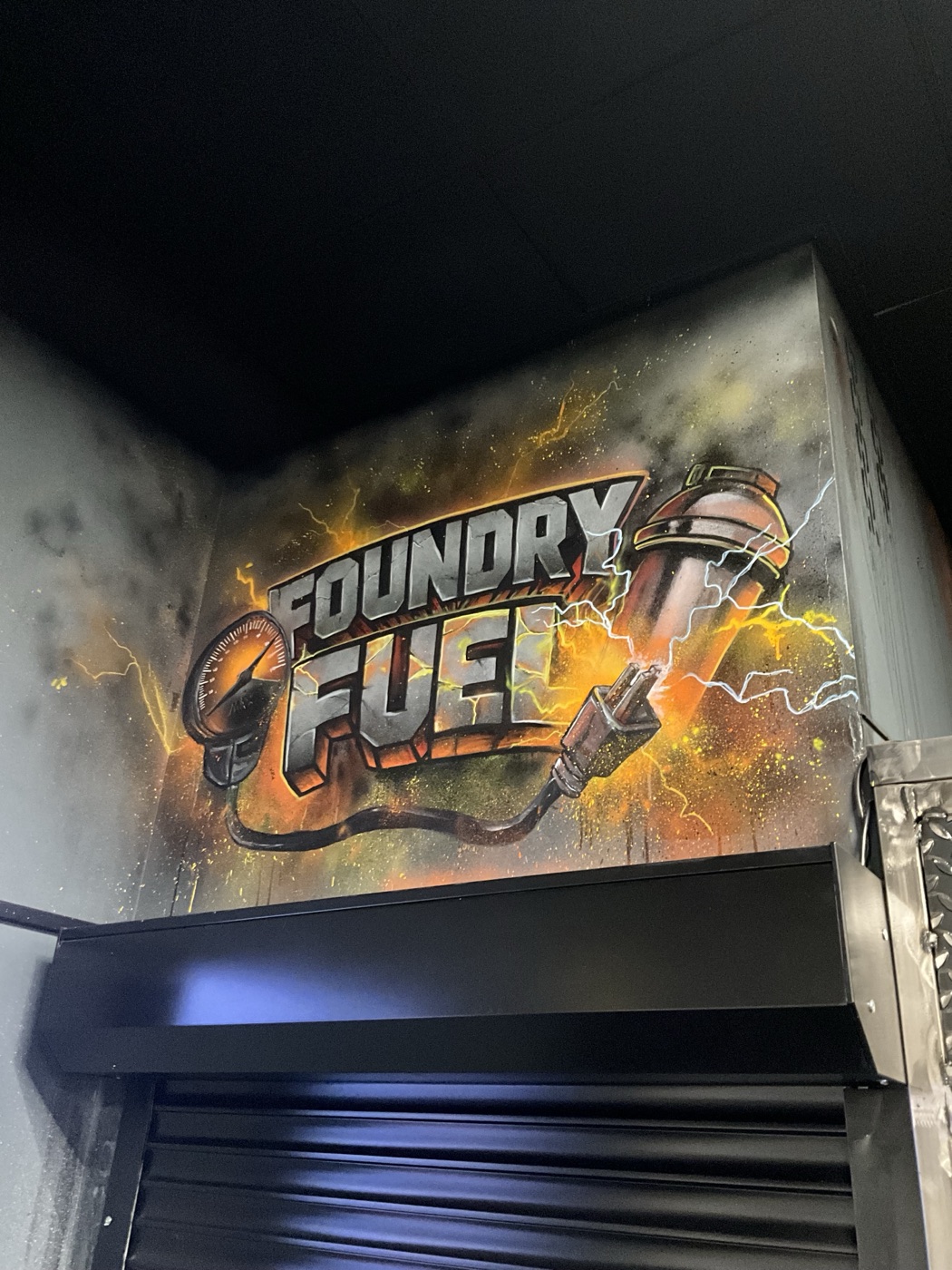 The ‘Foundry Fuel’ mural, industrial lettering wired to a plug and crackling with electricity