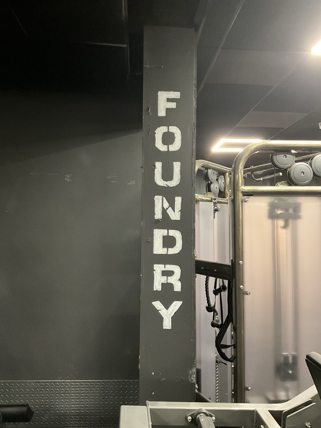 ‘Foundry’ hand-painted in bold stencil letters down a gym pillar