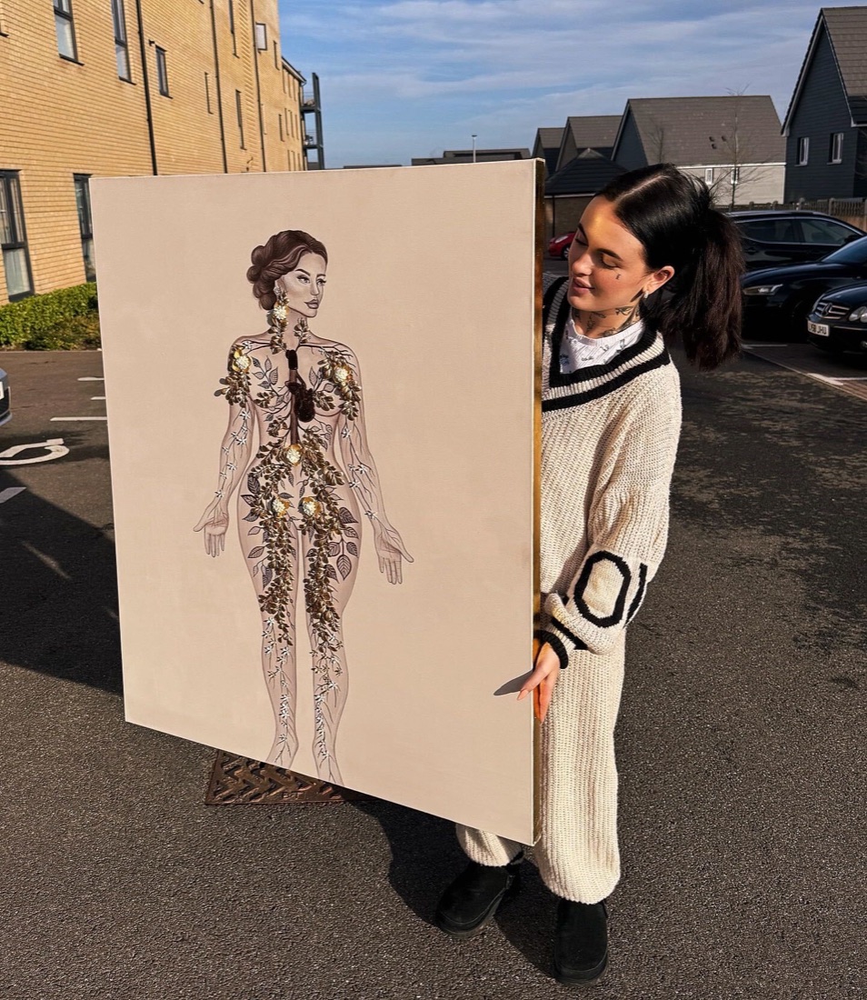 Niamh holding one of her detailed realist canvas paintings