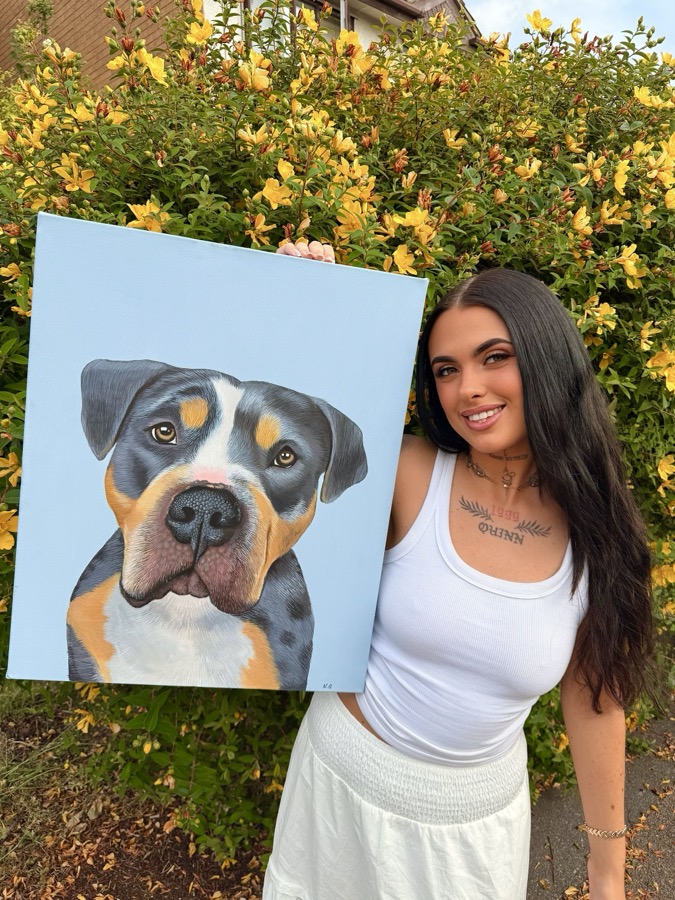 Niamh relaxed at home, holding her dog, creativity running through every corner of her life