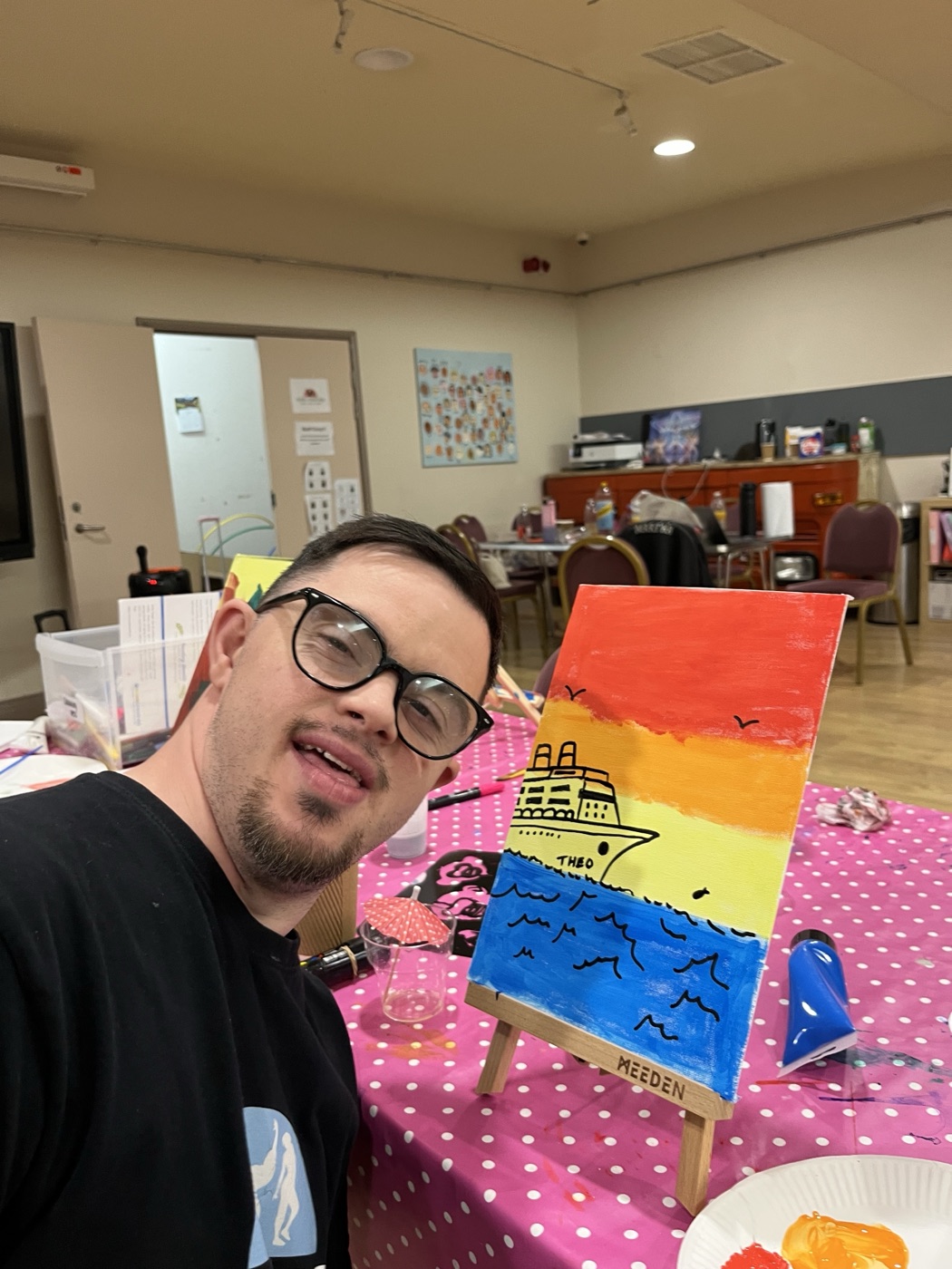 Someone beaming with the canvas they painted at a Patricia Studios party